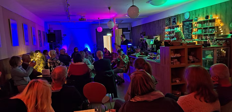 Besucher im Café mit Bühne und Lichteffekten